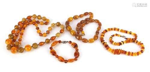 Three amber coloured bead necklaces and a bracelet, the largest 68cm in length, approximate weight