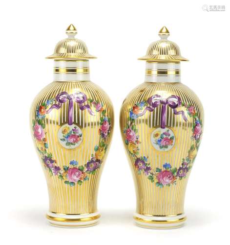 Pair of 19th century style baluster vases and covers, each hand painted and gilded with ribbons