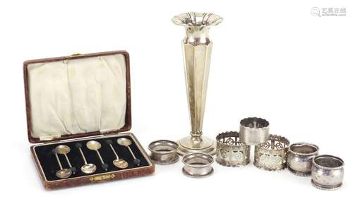 Silver items including a trumpet bud vase, napkin rings, set of six coffee bean spoons and two