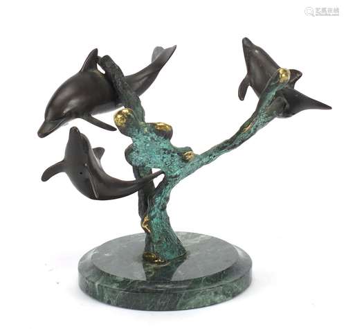 Naturalistic patinted bronze sculpture of three dolphins, raised on a circular green marble base,