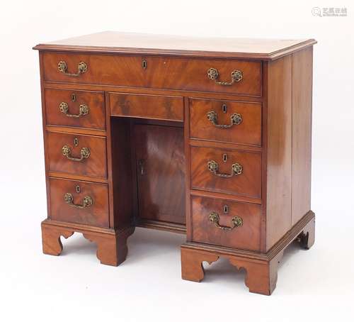 Victorian mahogany kneehole desk fitted with an arrangement of eight drawers and central cupboard