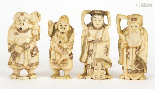 Four Japanese carved ivory Okimono's including one of a fisherman, one with character marks to the