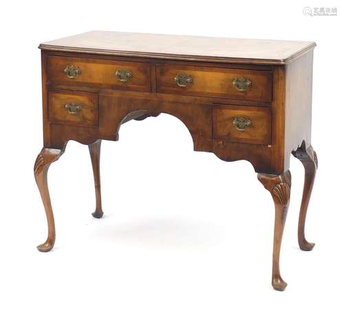 Walnut and mahogany cross banded low boy, fitted with four drawers on shell carved cabriole legs,