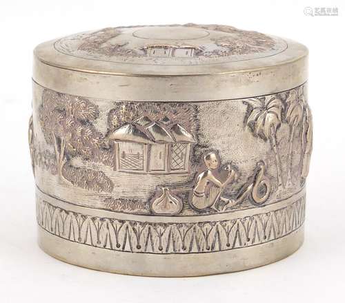 Indian unmarked silver cylindrical box and cover embossed with figures in a village, 7cm high x