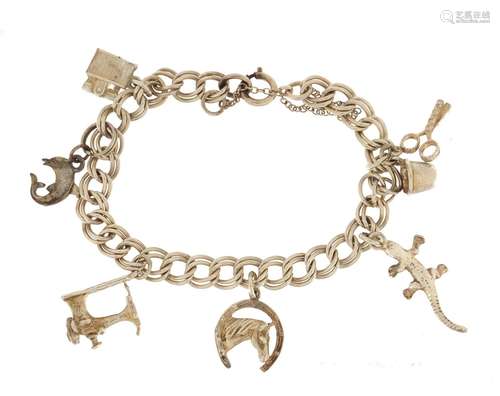 Silver charm bracelet with a selection of mostly silver charms including lighter, sewing machine and