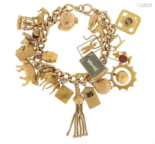 9ct gold charm bracelet with a large selection of mostly 9ct gold charms including bird in a cage,