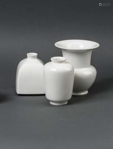 Drei VasenWeißporzellan. Eine Vase mit würfelförmigem Korpus, verkürztem Hals und enger Mündung,