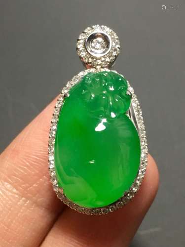 A GREEN JADEITE CARVED POCKET PENDANT, TYPE A