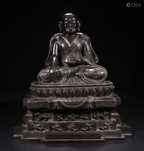 A COPPER SITTING BUDDHA FIGURE WITH EMBEDDED SILVER