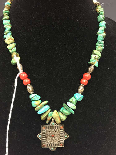 Tibetan turquoise necklace with metal pendant.