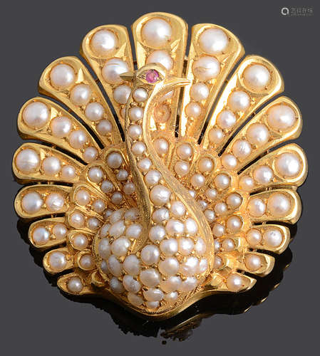 A Continental 18K gold and seed pearl pendant brooch in the form of a peacock