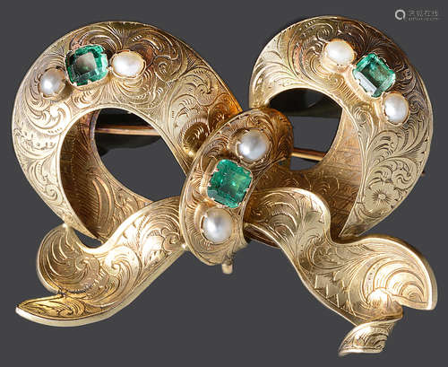 A Victorian emerald set tied ribbon design brooch