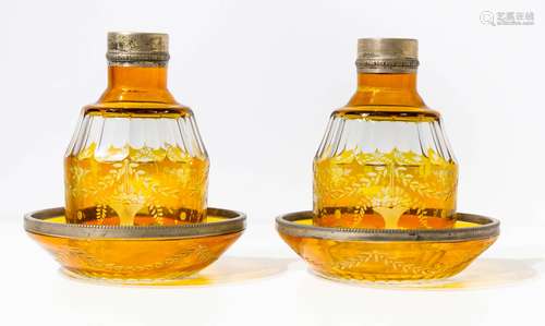 Pair of Bohemia crystal bottles, with flower decorations. H Cm 15,5, on yellow plates with silver