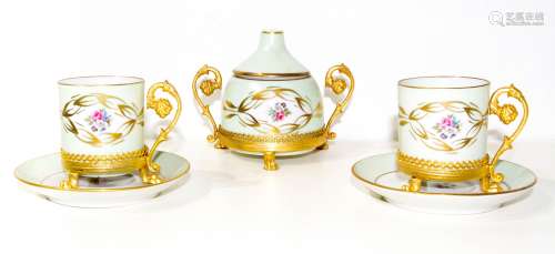 Limoges, France, 20th century. Pair of tea cups and a sugar bowl.