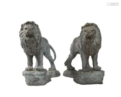 A pair of patinated metal standing lions