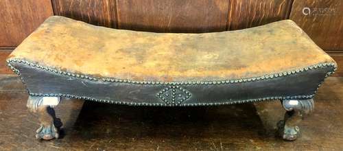 An antique studded brown leather upholstered foot stool