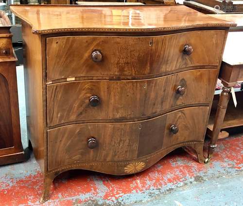 A Georgian mahogany serpentine commode chest of three long drawers