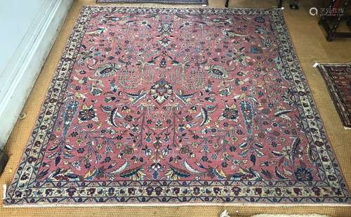 An antique Persian sarouk carpet, the overall floral design on salmon red ground