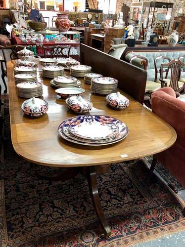 A Victorian style cross-banded mahogany triple pedestal dining table