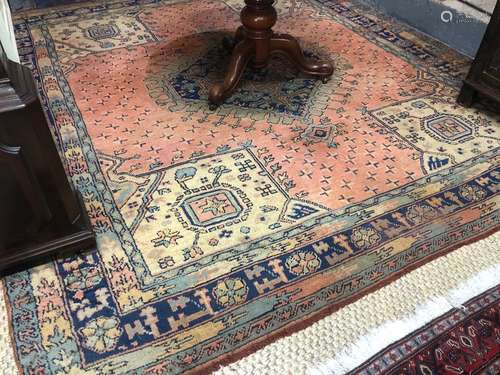 An old Turkish Oushak carpet, the pale red ground centred by a diamond lozenge