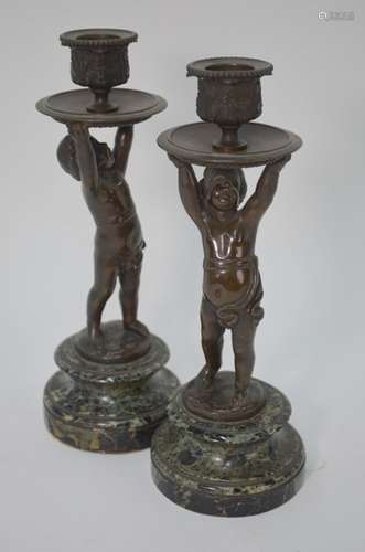 A pair of brown patinated bronze figural candlesticks