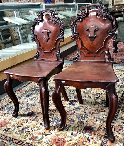 A pair of early Victorian mahogany hall chairs