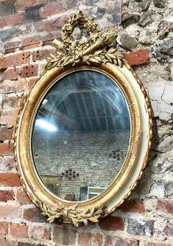 An old Empire style oval wall mirror