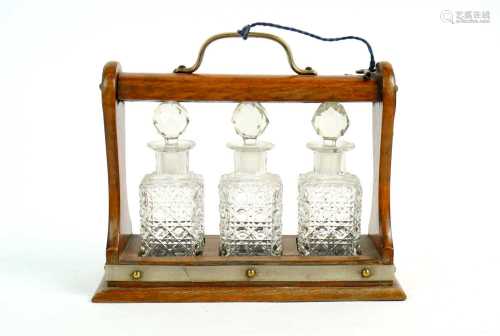 A Victorian miniature oak three decanter tantalus