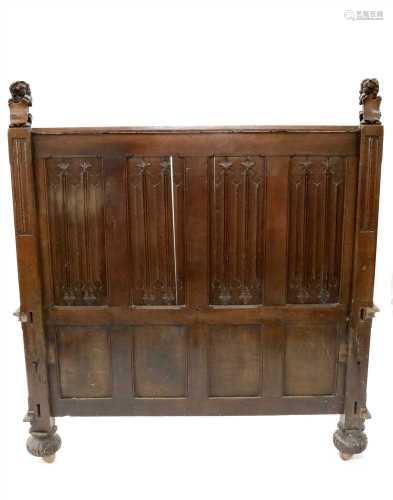 A large carved oak bed frame in the Old English style