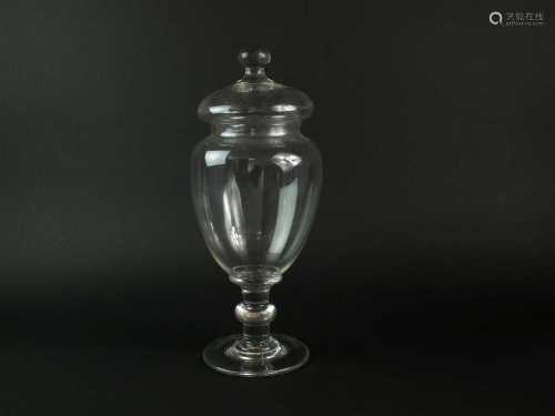 A large glass apothecary jar and cover