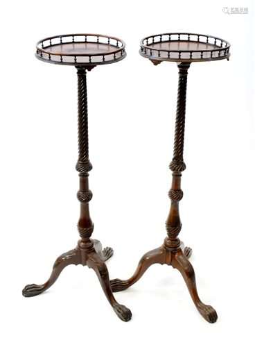 A near pair of George III style mahogany torchere stands