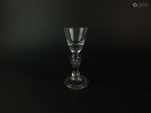 A heavy baluster wine or dram glass, circa 1710