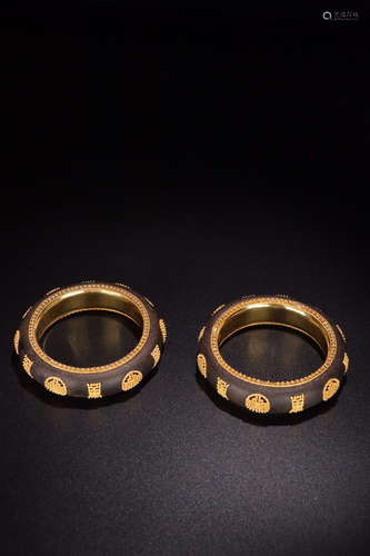 A PAIR OF CHENXIANG WOOD EMBEDED GOLD BANGLES