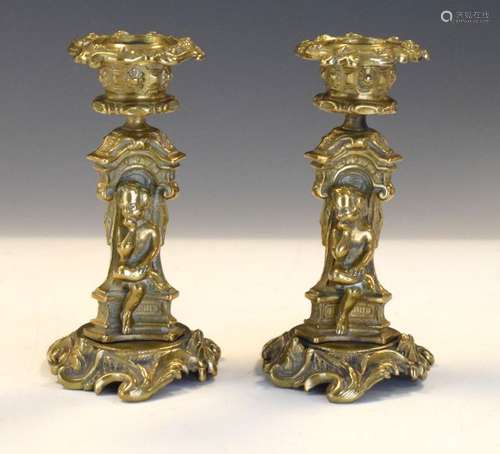 19th Century cast brass figural candlesticks, each with seated niche figures, and detachable nozzles