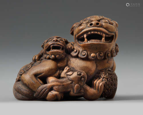 A wooden carving of three fu-lions