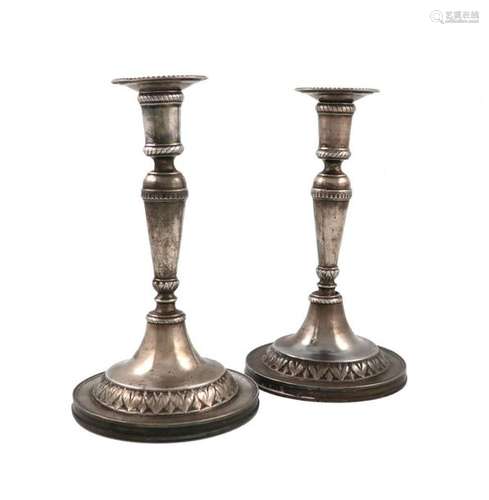 A pair of continental metalware candlesticks, unma…