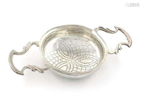 A George II silver two handled lemon strainer, mak…