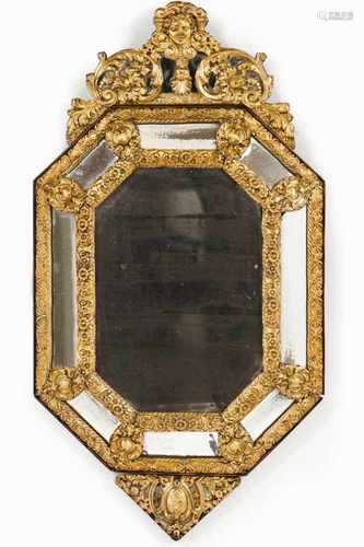 An octagonal wall mirrorWide frameRaised gilt metal decoration of foliage scrollsTop crest with