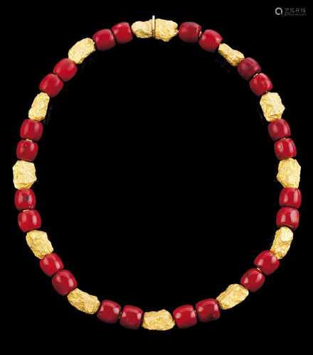 A necklaceGold and coralGold nugget shaped beads and coral beads threaded in gold; The encased clasp