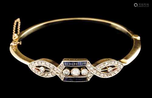 A bangle and broochBicoloured goldPlain band with geometric ornamentation, set with calibrated