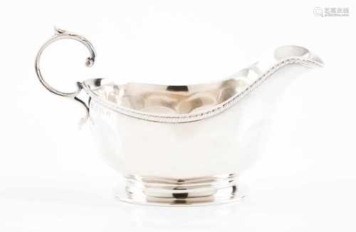 A sauce boatEnglish silverPart faceted body and volute handle with leaf detailBirmingham hallmark,