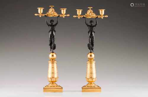 A pair of Empire style two branch candelabraPatinated and gilt bronzeFemale figure shaftFoliage