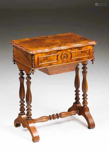 A sewing tableWalnutCarved legs and stretchersCompartmented interior and wool basketFrance, 19th