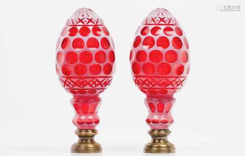 A pair of staircase finialsBlown red and white glassCut decorationBrass fittingsHeight: 27,5 cm