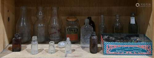 One shelf of vintage glass bottles in clear and brown