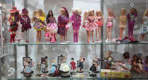 Two shelves of dolls, mostly Barbies, most dating to