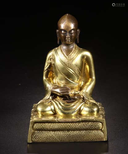 A GILT BRONZE FIGURE OF A SITTING GURU BUDDHA