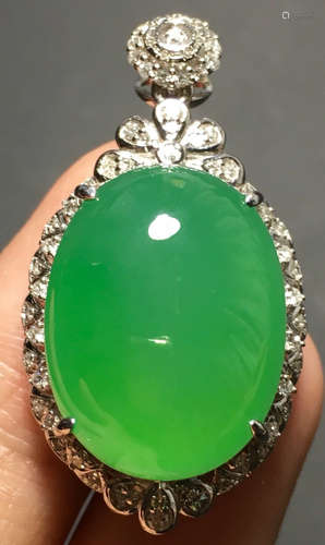 A GREEN JADEITE CARVED CIRCLE PENDANT, TYPE A