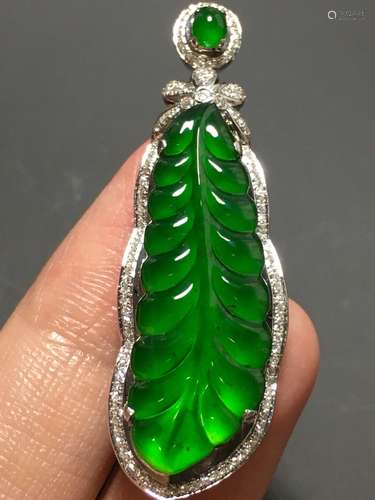 A GREEN JADEITE CARVED PENDANT, TYPE A