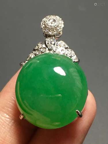 A GREEN JADEITE CARVED CIRCLE PENDANT, TYPE A